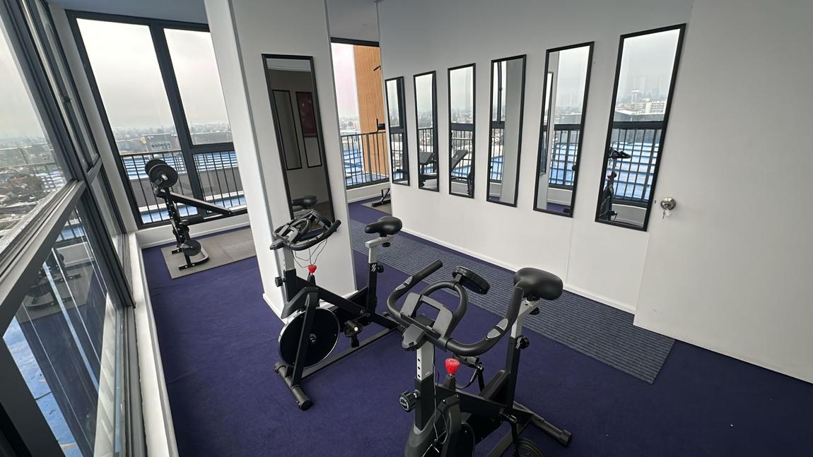 Gimnasio del Edificio Don Tomás, con máquinas y ventanal a la ciudad